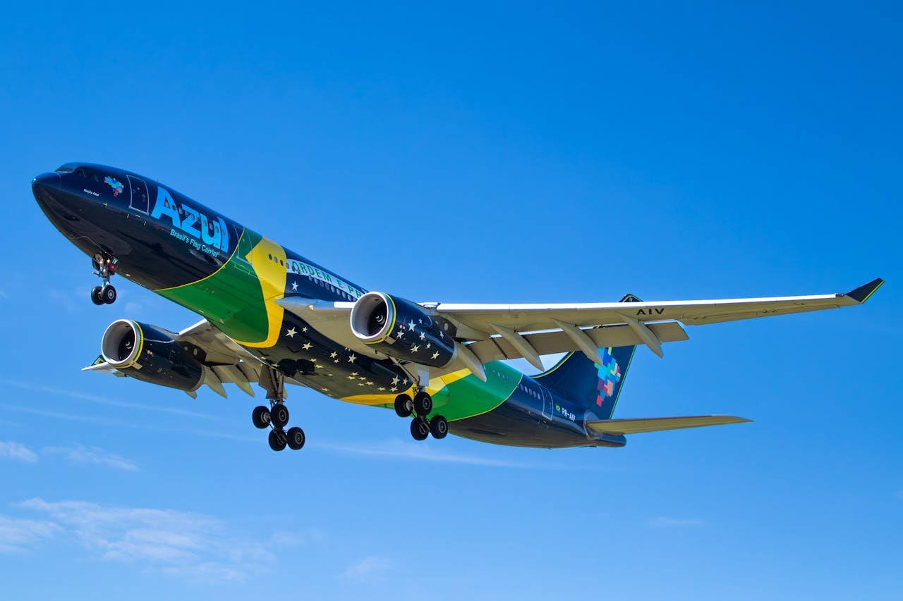 Azul Brazilian Airlines plane soaring under blue skies, showcasing vibrant national colors.